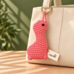 Pink Dino crochet dinosaur keychain in a lifestyle setting
