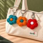Red crochet flower keychain in a lifestyle setting
