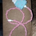 Blue crochet charger cover with pink decorative cable sleeve