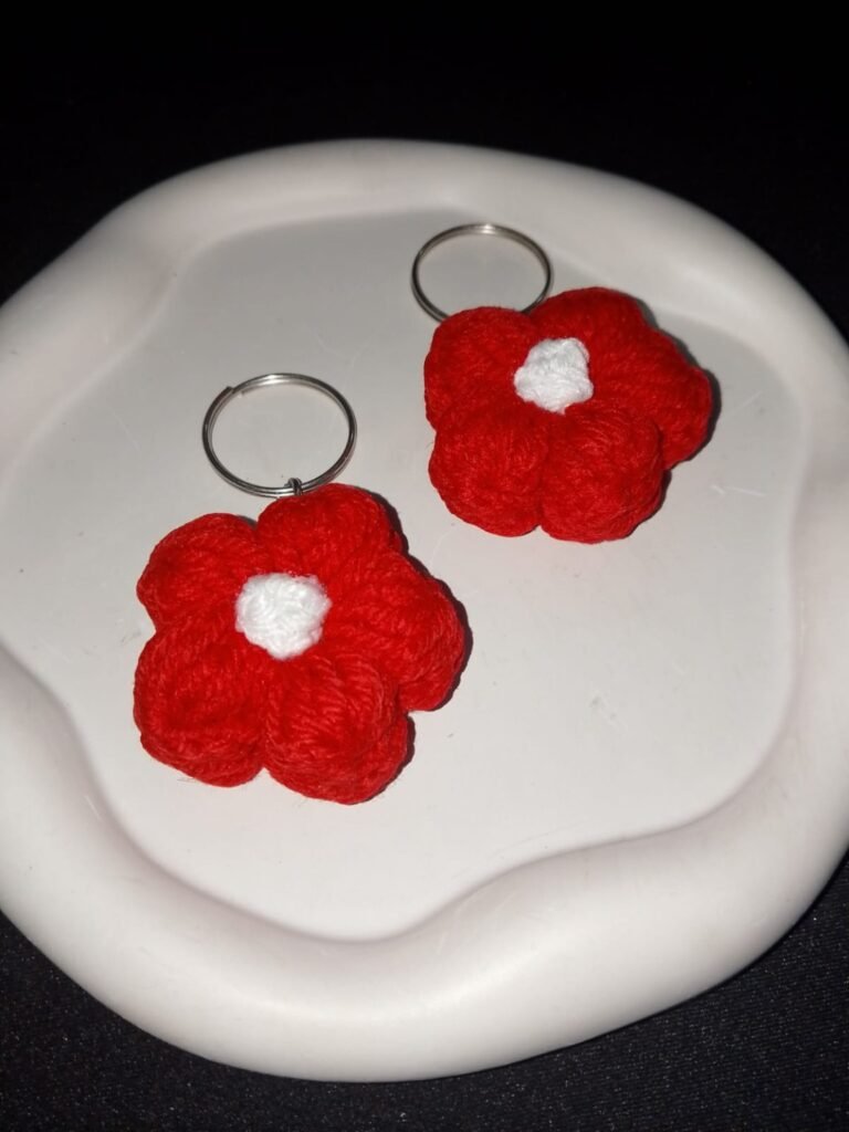 Red crochet flower keychains with white centres and metal rings