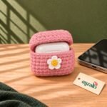Pink Daisy Earpods crochet cover by Ayzalo with an open wireless earbuds case