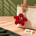 Pop Floral red chenille flower keychain with white stamen details attached to a handbag by Ayzalo