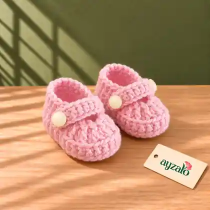 Bubblegum pink handmade crochet baby shoes with buttoned Mary Jane straps by Ayzalo